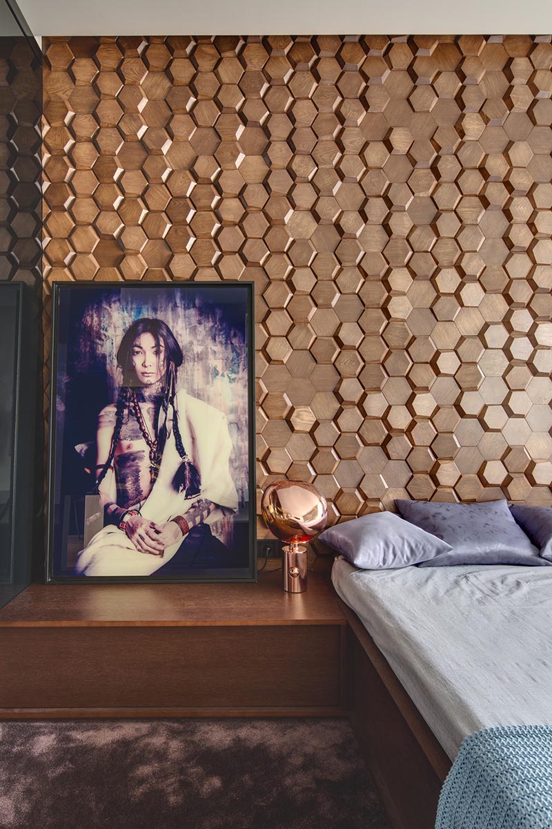 Phòng ngủ hiện đại này có một bức tường tạo điểm nhấn bắt mắt được làm từ gạch gỗ hình lục giác 3 chiều theo mô hình tổ ong.  #WoodTiles #WoodAccentWall # 3DAccentWall #BedroomDesign #InteriorDesign